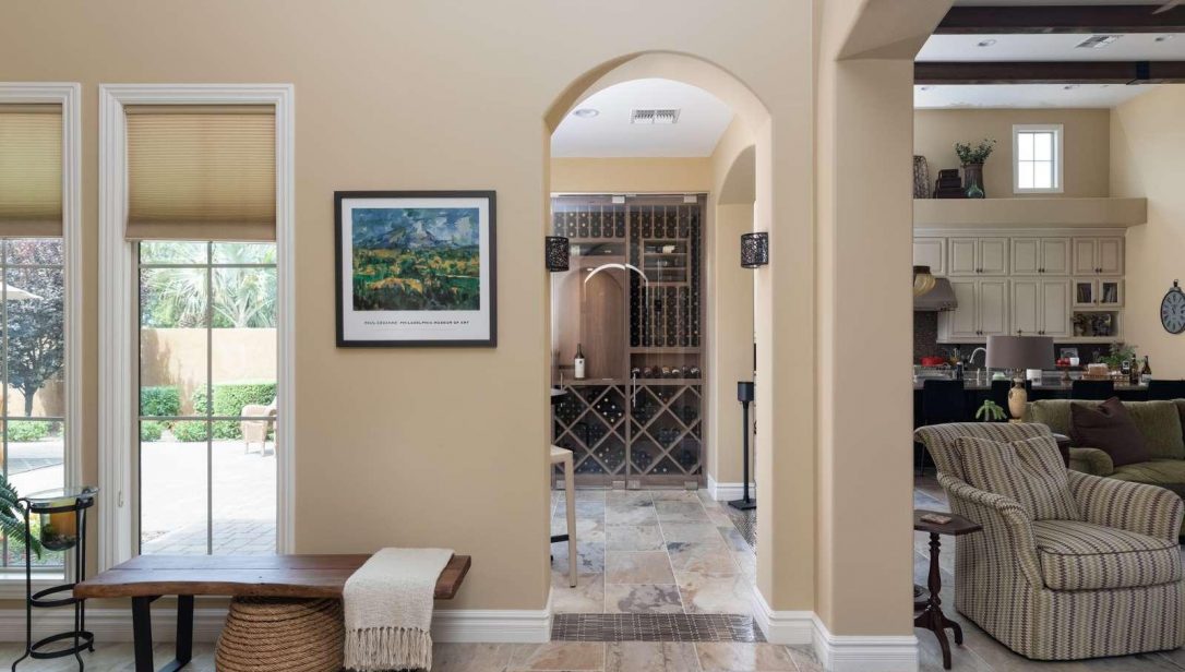 View through doorway in residential home to a glass enclosed wine cellar
