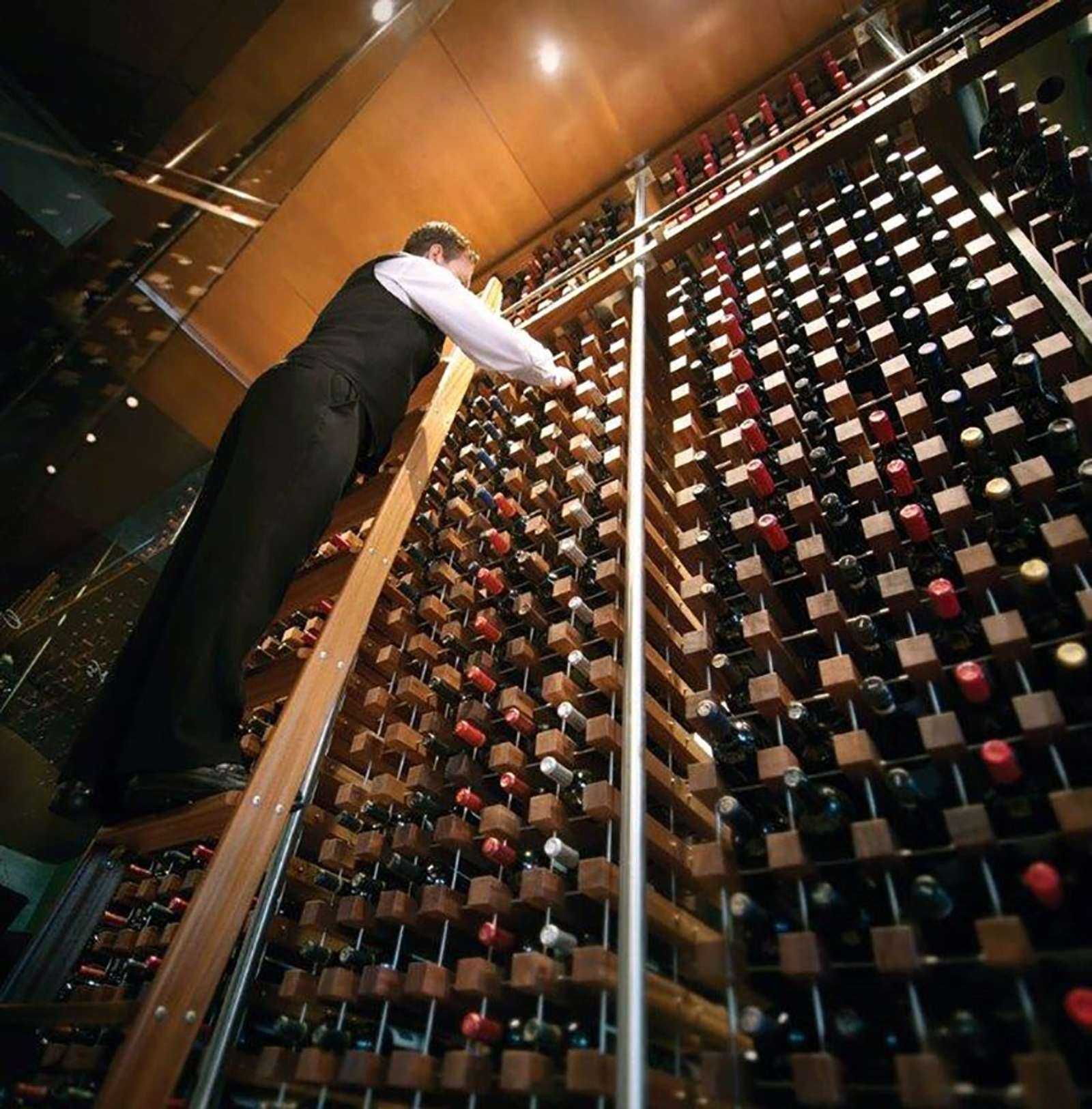 man on ladder in wine cellar